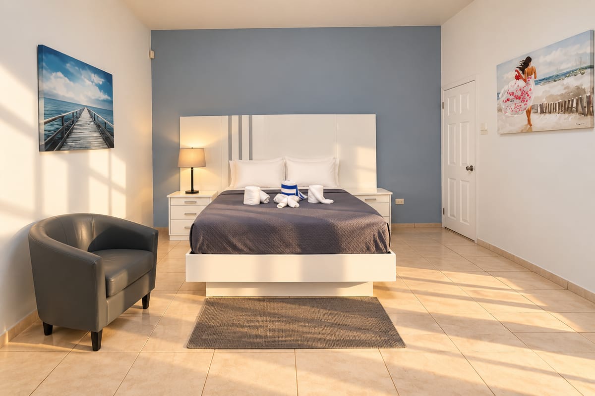 Cap Estate villa bedroom with white bed and armchair, Saint Lucia, Paris Villas
